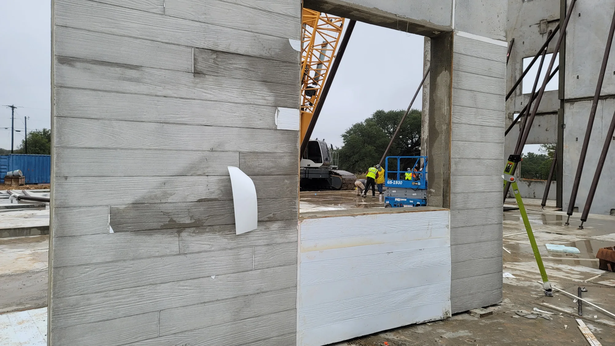 Wood plank pattern cast into a precast panel, standing on site with the crane behind it